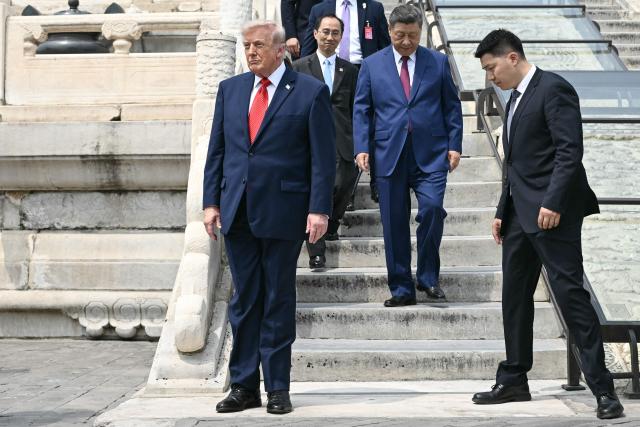 China's President Xi Jinping (2nd R) and US President Donald Trump (L) visit the Temple of Heaven in Beijing on May 14, 2026. Xi warned Trump that the issue of Taiwan could push their two countries into "conflict" if mishandled, a stark opening salvo as a superpower summit set to tackle numerous thorny issues began in Beijing on May 14. (Photo by Brendan SMIALOWSKI / POOL / AFP)