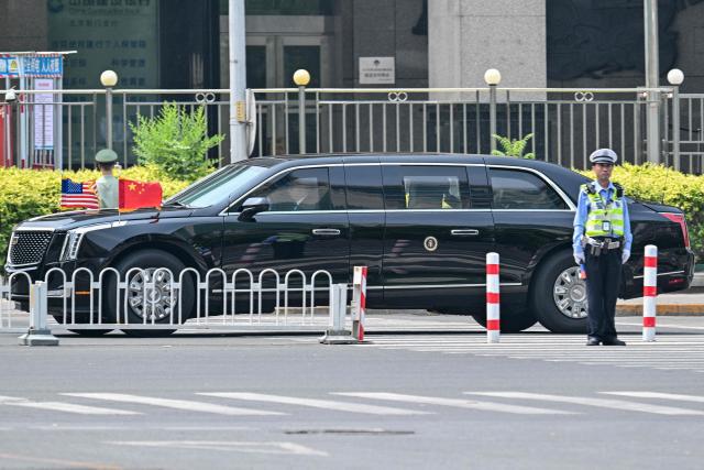 US President Donald Trump's official vehicle known as "The Beast" drives through Beijing on May 14, 2026. (Photo by HECTOR RETAMAL / AFP)