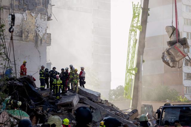 Rescuers and first responders operate at the site of a partially destroyed residential building following Russian drone and missile strikes in Kyiv on May 14, 2026, amid the Russian invasion of Ukraine. Russia launched more than 670 drones and 56 missiles at Ukraine overnight, Ukraine's President announced on May 14, 2026. (Photo by Tetiana DZHAFAROVA / AFP)