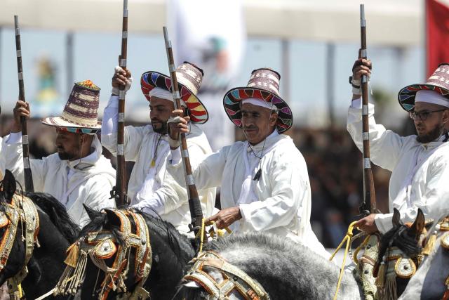 Men dressed in traditional attire ride horses during a Tbourida, or Fantasia, equestrian performance in the city of Bouznika on May 13, 2026. (Photo by Abdel Majid BZIOUAT / AFP)