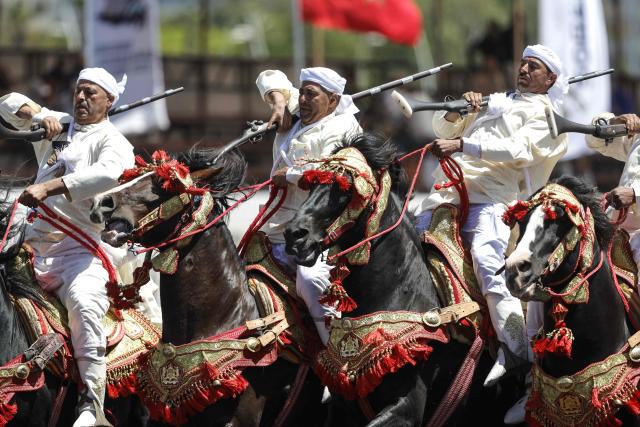 Men dressed in traditional attire ride horses during a Tbourida, or Fantasia, equestrian performance in the city of Bouznika on May 13, 2026. (Photo by Abdel Majid BZIOUAT / AFP)