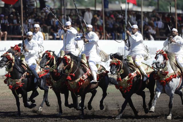 Men dressed in traditional attire ride horses during a Tbourida, or Fantasia, equestrian performance in the city of Bouznika on May 13, 2026. (Photo by Abdel Majid BZIOUAT / AFP)