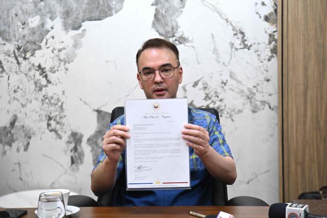 Philippine Senate President Alan Peter Cayetano shows members of the media the confirmation letter that the Senate received the articles of impeachment for Vice President Sara Duterte at his office in the Senate in Manila on May 14, 2026, a day after gun shots were fired inside the building. Police said May 14 they detained a person in connection with gunfire the previous night inside the Philippine senate, where a lawmaker wanted by the International Criminal Court took refuge. (Photo by TED ALJIBE / AFP)