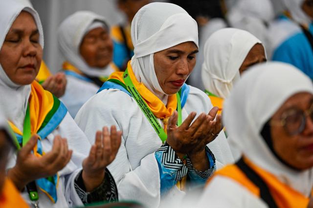 Prospective Indonesian hajj pilgrims pray during a pre-departure safety training session at the hajj embarkation centre in Banda Aceh on May 14, 2026. (Photo by CHAIDEER MAHYUDDIN / AFP)