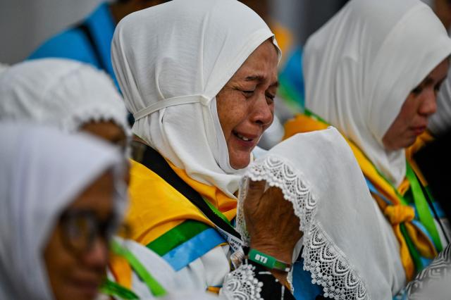 A prospective Indonesian hajj pilgrim cries while praying during a pre-departure safety training session at the hajj embarkation centre in Banda Aceh on May 14, 2026. (Photo by CHAIDEER MAHYUDDIN / AFP)