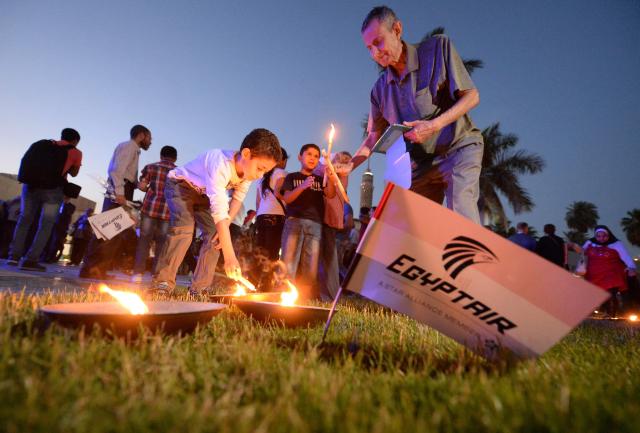 (FILES) Egyptians light candles during a candlelight vigil for the 66 victims of the EgyptAir MS804 flight that crashed in the Mediterranean Sea, at the Cairo Opera House in the Egyptian capital on May 26, 2016. Ten years after the deaths of 66 people, including 15 French nationals, in the EgyptAir crash in the Mediterranean, the Paris public prosecutor's office has recommended that the case be dropped on the grounds that the investigation "has not identified any negligence other than that" of the crew members, all of whom died, AFP learned on May 14, 2026, from a source close to the case. (Photo by KHALED DESOUKI / AFP)