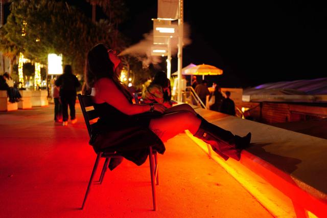 A woman smokes as she sits on a chair on the Boulevard de la Croisette on the sidelines at the 79th edition of the Cannes Film Festival in Cannes, southern France on May 13, 2026. (Photo by VALERY HACHE / AFP)