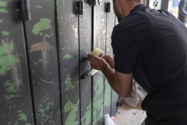 A Palestinian man closes his shop in the old city of Jerusalem ahead of Jerusalem day parade on May 14, 2026. Every year, thousands of Israeli nationalists, many of them religious Jews, march through Jerusalem and its annexed Old City, including in predominantly Palestinian neighbourhoods, waving Israeli flags, dancing and sometimes shouting inflammatory slogans. (Photo by ilia YEFIMOVICH / AFP)