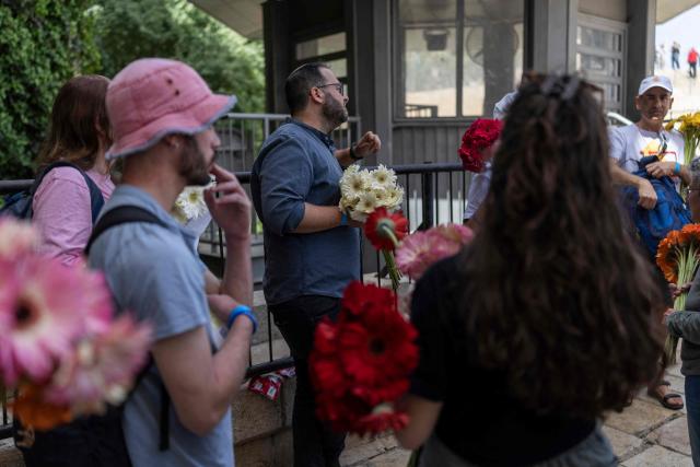 Israeli left-wing activists walk with flowers in hand to give to the Palestinian population of the old city in Jerusalem ahead of Jerusalem day parade on May 14, 2026. Every year, thousands of Israeli nationalists, many of them religious Jews, march through Jerusalem and its annexed Old City, including in predominantly Palestinian neighbourhoods, waving Israeli flags, dancing and sometimes shouting inflammatory slogans. (Photo by ilia YEFIMOVICH / AFP)