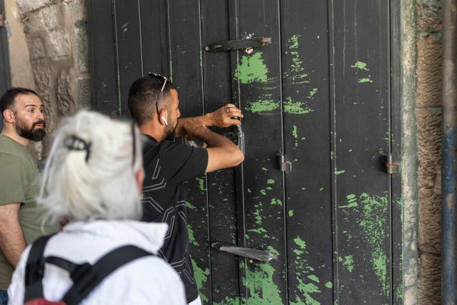 A Palestinian man closes his shop in the old city of Jerusalem ahead of Jerusalem day parade on May 14, 2026. Every year, thousands of Israeli nationalists, many of them religious Jews, march through Jerusalem and its annexed Old City, including in predominantly Palestinian neighbourhoods, waving Israeli flags, dancing and sometimes shouting inflammatory slogans. (Photo by ilia YEFIMOVICH / AFP)