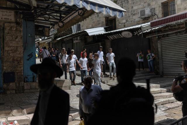Israeli settlers walk around in the old city of Jerusalem ahead of Jerusalem day parade on May 14, 2026. Every year, thousands of Israeli nationalists, many of them religious Jews, march through Jerusalem and its annexed Old City, including in predominantly Palestinian neighbourhoods, waving Israeli flags, dancing and sometimes shouting inflammatory slogans. (Photo by ilia YEFIMOVICH / AFP)