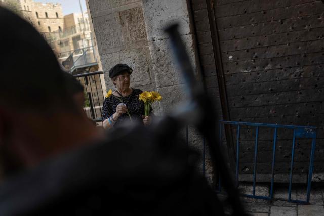 An Israeli left-wing activist holds flowers in hand to give to the Palestinian population of the old city in Jerusalem ahead of Jerusalem day parade on May 14, 2026. Every year, thousands of Israeli nationalists, many of them religious Jews, march through Jerusalem and its annexed Old City, including in predominantly Palestinian neighbourhoods, waving Israeli flags, dancing and sometimes shouting inflammatory slogans. (Photo by ilia YEFIMOVICH / AFP)