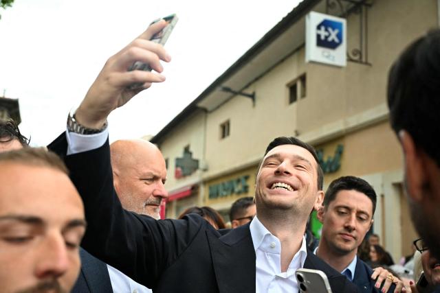 French far-right party Rassemblement National (RN) president Jordan Bardella poses for a selfie during a visit in Beaucaire, southern France on May 14, 2026. (Photo by Gabriel BOUYS / AFP)