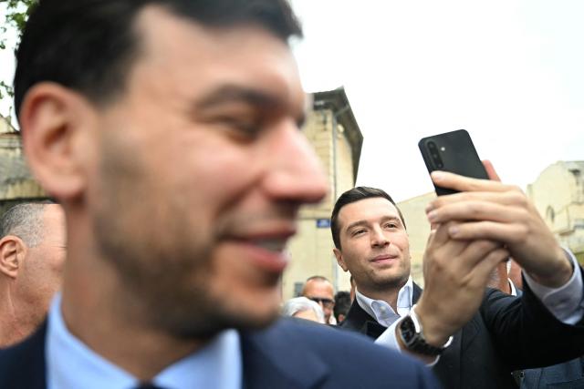 French far-right party Rassemblement National (RN) president Jordan Bardella poses for a selfie during a visit in Beaucaire, southern France on May 14, 2026. (Photo by Gabriel BOUYS / AFP)