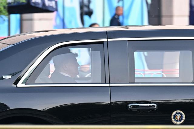 US President Donald Trump sits in his official vehicle known as "The Beast" as the motorcade drives through Beijing on May 14, 2026. (Photo by HECTOR RETAMAL / AFP)