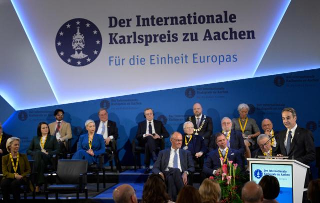 Greek Prime Minister Kyriakos Mitsotakis (R) gives a speech during a ceremony to award the former President of the European Central Bank (ECB) and former Italian Prime Minister Mario Draghi (C) with the 2026 International Charlemagne Prize of Aachen, on May 14, 2026 in Aachen, western Germany. (Photo by Sascha Schuermann / AFP)