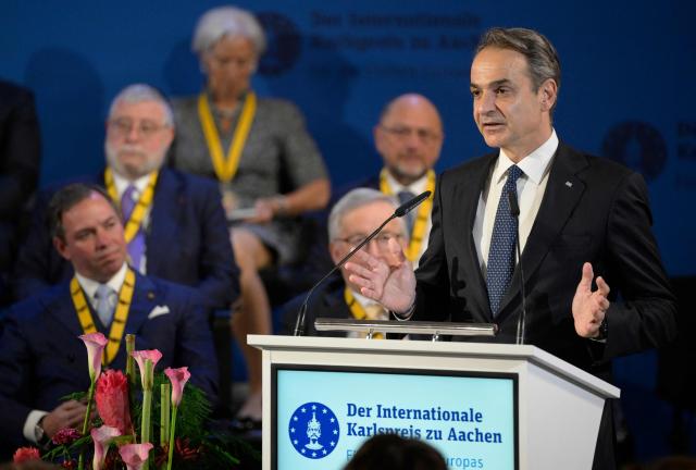 Greek Prime Minister Kyriakos Mitsotakis (R) gives a speech during a ceremony to award the former President of the European Central Bank (ECB) and former Italian Prime Minister Mario Draghi (L) with the 2026 International Charlemagne Prize of Aachen, on May 14, 2026 in Aachen, western Germany. (Photo by Sascha Schuermann / AFP)