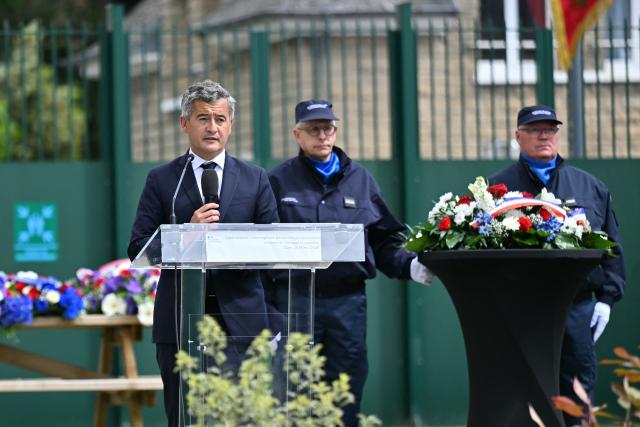 France's Justice Minister Gerald Darmanin (L) delivers a speech as he takes part in a visit marking the second anniversary of the 2024 Incarville attack, at the Pole de Rattachement dExtractions Judiciaires - PREJ (Judicial Extraction Coordination Centre) in Caen, north-western France on May 14, 2026. On May 14, 2024, a group of gunmen killed two prison officers and wounded three others, in an attack of a prison van transporting inmate Mohamed Amra at a motorway toll in Incarville, northern France. Amra's deadly escape marked a "turning point" in France, speeding up the introduction of new investigative tools and the construction of new prisons. However, investigators still face challenges in the face of a rapidly growing organised crime scene. (Photo by LOU BENOIST / AFP)