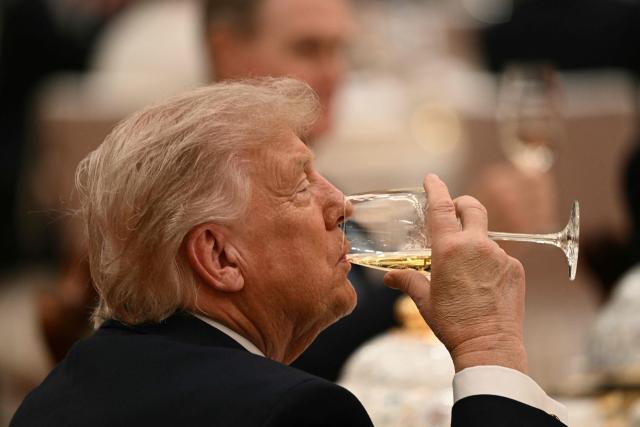 US President Donald Trump drinks as he attends a state banquet with China's President Xi Jinping at the Great Hall of the People in Beijing on May 14, 2026. (Photo by Brendan SMIALOWSKI / AFP)