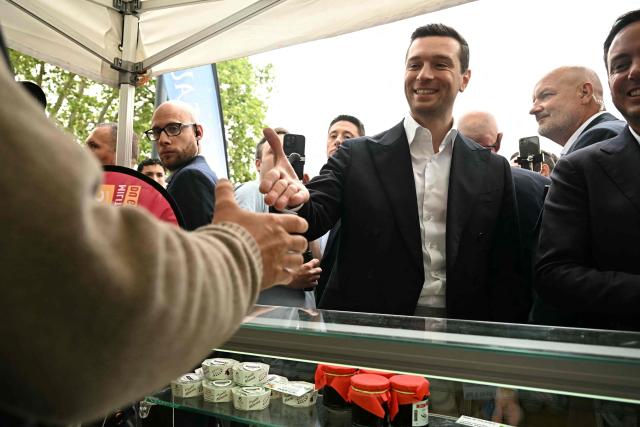 French far-right party Rassemblement National (RN) president Jordan Bardella shakes hands with a vendor during a visit in Beaucaire, southern France on May 14, 2026. (Photo by Gabriel BOUYS / AFP)
