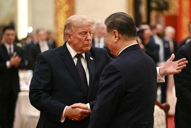 China's President Xi Jinping (R) and US President Donald Trump shake hands as they attend a state banquet at the Great Hall of the People in Beijing on May 14, 2026. (Photo by Brendan SMIALOWSKI / AFP)