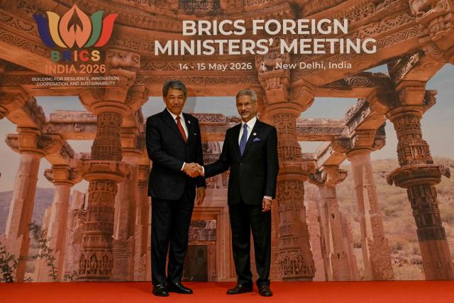 India's Foreign Minister Subrahmanyam Jaishankar (R) shakes hands with his Malaysian counterpart Mohamad Hasan during the BRICS Foreign Ministers’ meeting at the Bharat Mandapam in New Delhi on May 14, 2026. (Photo by Arun SANKAR / AFP)
