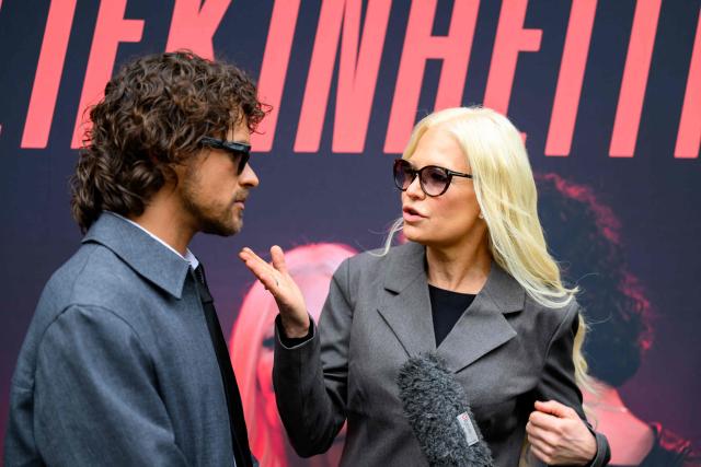 Finnish singers Linda Lampenius (R) and Pete Parkkonen, representing Finland with the song 'Liekinheitin' give an interview on the sidelines of the Eurovision Song Contest 2026 (ESC) in Vienna, Austria on May 14, 2026, before the second semi-final of the contest. (Photo by MAX SLOVENCIK / APA / AFP) / Austria OUT