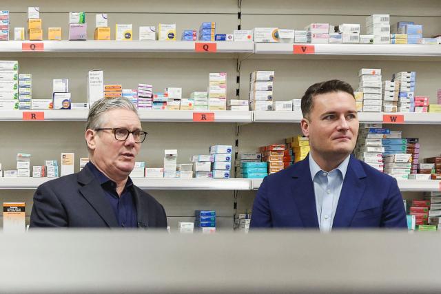 (FILES) Britain's Prime Minister Keir Starmer (2nd R) and Health Secretary Wes Streeting (R) talk with lead pharmacist Mahendranathan Mayoorigah (2nd L) and pharmacy manager Abdul Abid (L) during a visit to the Nelson Medical Practice health centre in Wimbledon, southwest London on January 26, 2026. Britain's Health Secretary Wes Streeting, possible rival to Britain's Prime Minister Keir Starmer, announced his resignation on May 14, 2026. (Photo by ADRIAN DENNIS / POOL / AFP)