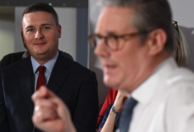 (FILES) Britain's Health Secretary Wes Streeting (L) listens as Britain's Prime Minister Keir Starmer delivers a speech on a plan to reduce NHS waiting times, during a visit to the South West London Elective Orthopaedic Centre (SWLEOC) in Epsom, south-west of London on January 6, 2025. Britain's Health Secretary Wes Streeting, possible rival to Britain's Prime Minister Keir Starmer, announced his resignation on May 14, 2026. (Photo by Leon Neal / POOL / AFP)