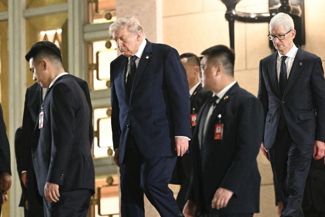 US President Donald Trump (C) and Apple CEO Tim Cook (R) after a state banquet with China's President Xi Jinping at the Great Hall of the People in Beijing on May 14, 2026. (Photo by Brendan SMIALOWSKI / AFP)