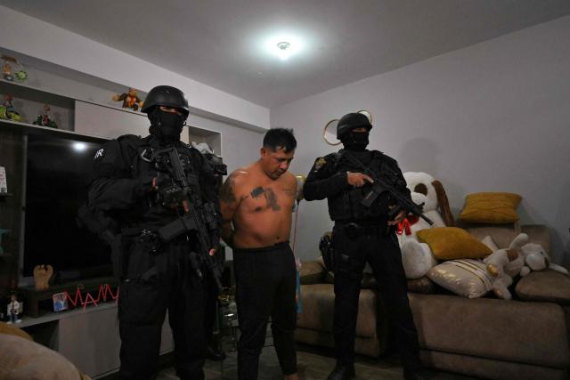 Police arrest Eduardo Gomez, alias "Gordo Paul", a leader of Los Lobos drug trafficking group, during a curfew imposed by Ecuador's President Daniel Noboa to tackle organized crime, in Quito in the early hours of May 14, 2026. Ecuador's police on May 14 captured a "dangerous" leader of Los Lobos, the country's largest drug trafficking group, in a cinematic operation led by Interior Minister Jhon Reimberg, AFP reporters witnessed. (Photo by Rodrigo BUENDIA / AFP)