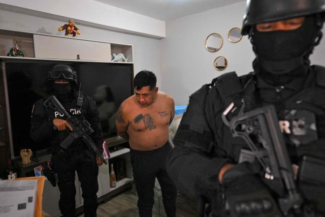 Police arrest Eduardo Gomez, alias "Gordo Paul", a leader of Los Lobos drug trafficking group, during a curfew imposed by Ecuador's President Daniel Noboa to tackle organized crime, in Quito in the early hours of May 14, 2026. Ecuador's police on May 14 captured a "dangerous" leader of Los Lobos, the country's largest drug trafficking group, in a cinematic operation led by Interior Minister Jhon Reimberg, AFP reporters witnessed. (Photo by Rodrigo BUENDIA / AFP)