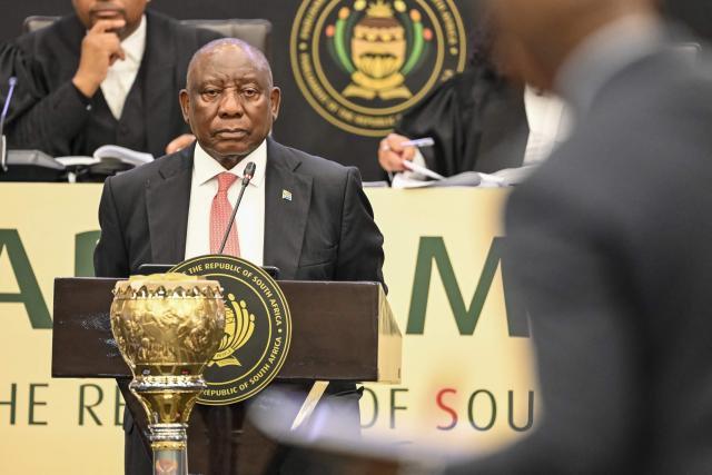 South Africa's President Cyril Ramaphosa (L) as member of Parliament for Build One South Africa Mmusi Maimane asks him a question in Parliament in Cape Town on May 14, 2026. (Photo by RODGER BOSCH / AFP)