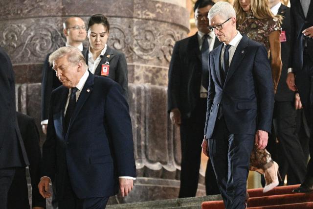 US President Donald Trump (L) and Apple CEO Tim Cook (R) leave after a state banquet with China's President Xi Jinping at the Great Hall of the People in Beijing on May 14, 2026. (Photo by Brendan SMIALOWSKI / AFP)