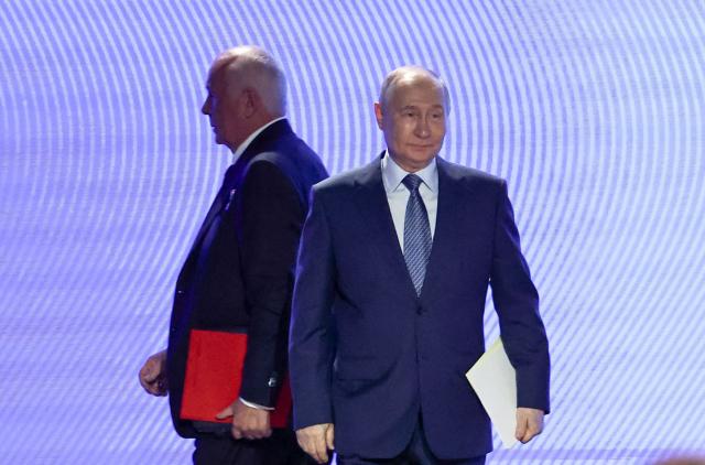 In this pool photograph distributed by the Russian state agency Sputnik, Russia's President Vladimir Putin and Sergei Chemezov, CEO of Rostec, attend the 10th Congress of the Union of Machine Builders in Moscow on May 14, 2026. (Photo by Mikhail TERESHCHENKO / POOL / AFP)