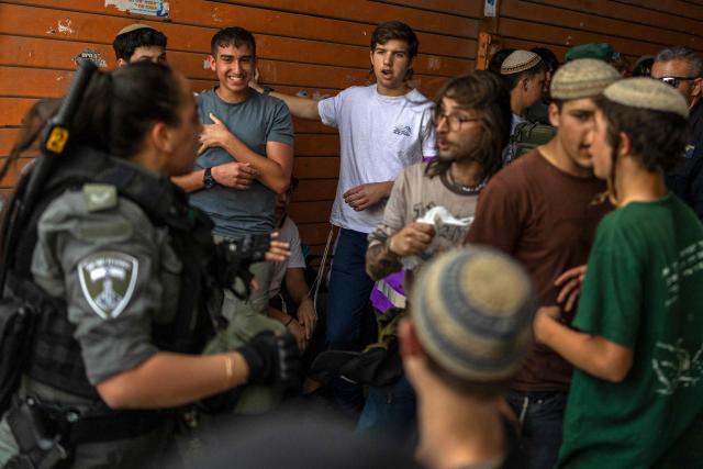 Police stand between Israeli settlers scuffling with left-wing activists in the old city of Jerusalem during the Jerusalem Day parade on May 14, 2026. Every year, thousands of Israeli nationalists, many of them religious Jews, march through Jerusalem and its annexed Old City, including in predominantly Palestinian neighbourhoods, waving Israeli flags, dancing and sometimes shouting inflammatory slogans. (Photo by ilia YEFIMOVICH / AFP)