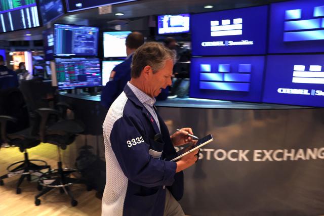 A trader works on the floor of the New York Stock Exchange (NYSE) at the opening bell in New York on May 14, 2026. Wall Street stocks rose early Thursday on positive sentiment about the US-China summit and strong Cisco earnings that reinforced confidence in artificial intelligence growth. (Photo by TIMOTHY A. CLARY / AFP)