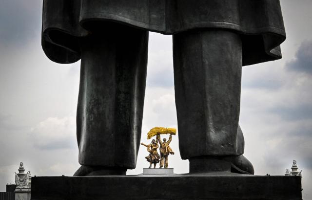 A part of the monument to the Soviet Union founder Vladimir Lenin is seen in front of a sculpture group at the main entrance of the All-Russia Exhibition Centre (VDNKh) in Moscow on May 14, 2026. (Photo by Alexander NEMENOV / AFP)