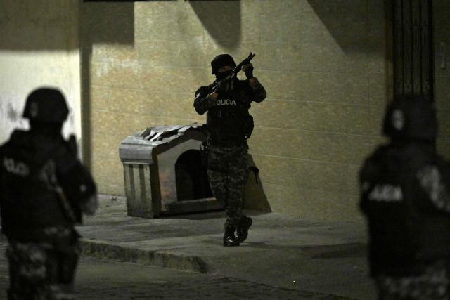 A police officer aims his rifle during a police operation to arrest Eduardo Gomez, alias "Gordo Paul", carried out during a curfew imposed by President Daniel Noboa to tackle organized crime, in Quito in the early hours of May 14, 2026. Ecuador's police on May 14 captured a "dangerous" leader of Los Lobos, the country's largest drug trafficking group, in a cinematic operation led by Interior Minister Jhon Reimberg, AFP reporters witnessed. (Photo by Rodrigo BUENDIA / AFP)
