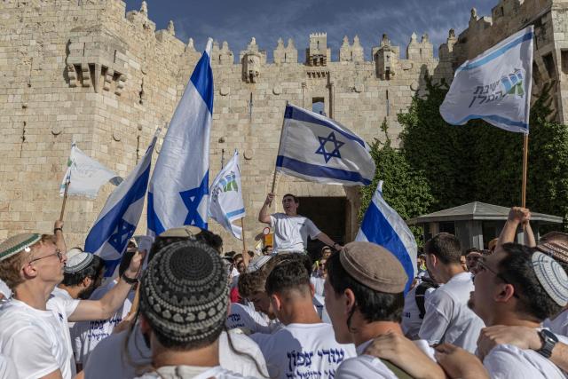 Israeli settlers take part in the Jerusalem Day parade at the Damascus Gate in the old city of Jerusalem on May 14, 2026. Every year, thousands of Israeli nationalists, many of them religious Jews, march through Jerusalem and its annexed Old City, including in predominantly Palestinian neighbourhoods, waving Israeli flags, dancing and sometimes shouting inflammatory slogans. (Photo by ilia YEFIMOVICH / AFP)