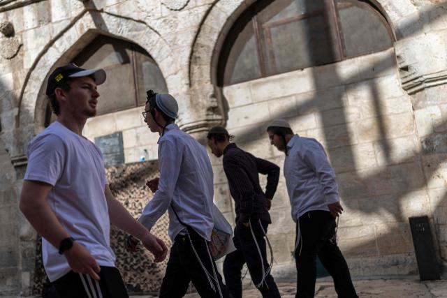 Israeli settlers walk through the old city of Jerusalem, during the Jerusalem Day parade on May 14, 2026. Every year, thousands of Israeli nationalists, many of them religious Jews, march through Jerusalem and its annexed Old City, including in predominantly Palestinian neighbourhoods, waving Israeli flags, dancing and sometimes shouting inflammatory slogans. (Photo by ilia YEFIMOVICH / AFP)