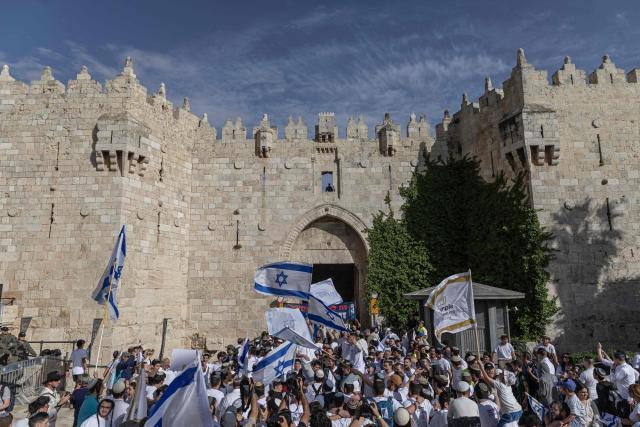 Israeli settlers take part in the Jerusalem Day parade at the Damascus Gate in the old city of Jerusalem on May 14, 2026. Every year, thousands of Israeli nationalists, many of them religious Jews, march through Jerusalem and its annexed Old City, including in predominantly Palestinian neighbourhoods, waving Israeli flags, dancing and sometimes shouting inflammatory slogans. (Photo by ilia YEFIMOVICH / AFP)