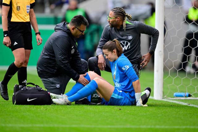 VfL Wolfsburg's German goalkeeper #01 Stina Johannes (R, bottom) reacts on the ground while attended for an injury during the Women's German Cup (DFB-Pokal) final football match between VfL Wolfsburg and FC Bayern Munich in Cologne, western Germany, on Mai 14, 2026. (Photo by INA FASSBENDER / AFP) / DFB REGULATIONS PROHIBIT ANY USE OF PHOTOGRAPHS AS IMAGE SEQUENCES AND QUASI-VIDEO.