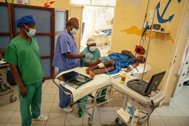 A surgeon working with the International Committee of the Red Cross (ICRC) examines a gunshot-wounded patient using a sonar device to locate a fragment lodged in the patient’s leg, at a hospital in Goma on May 14, 2026. (Photo by Jospin Mwisha / AFP)