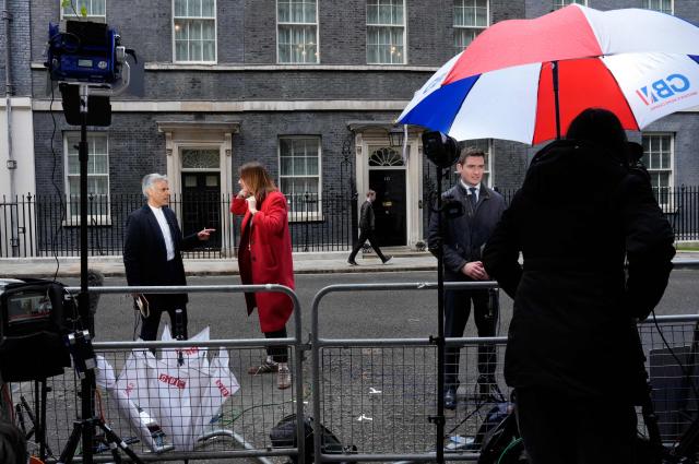 Members of the media including the BBC's Matthew Amroliwala (L), and a GB News presenter Tom Harwood (R), work opposite the door to outside 10 Downing Street in central London on May 14, 2026. Wes Streeting announced Thursday that he has resigned as Britain's health minister, paving the way for a potential leadership challenge against embattled Prime Minister Keir Starmer. In his resignation letter to the prime minister, which Streeting posted on X, he said he had "lost confidence" in Starmer's leadership and "it is now clear that you will not lead the Labour Party into the next general election". (Photo by CARLOS JASSO / AFP)