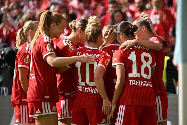 Bayern Munich's English midfielder #31 Georgia Stanway (hidden) is celebrated by team mates after scoring the 0-1 opening goal with a penalty kick during the Women's German Cup (DFB-Pokal) final football match between VfL Wolfsburg and FC Bayern Munich in Cologne, western Germany, on Mai 14, 2026. (Photo by INA FASSBENDER / AFP) / DFB REGULATIONS PROHIBIT ANY USE OF PHOTOGRAPHS AS IMAGE SEQUENCES AND QUASI-VIDEO.