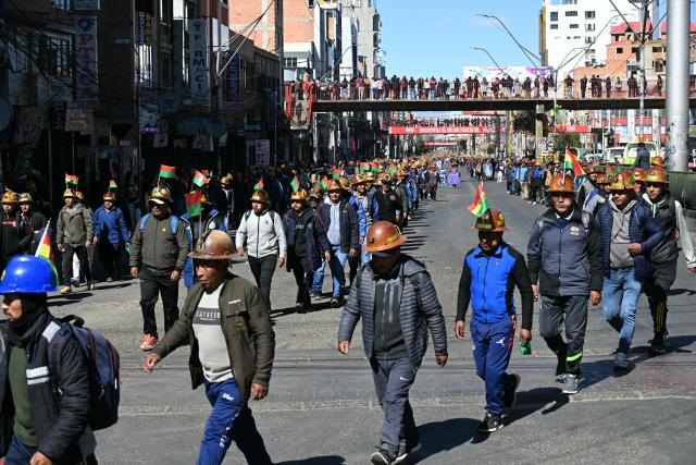 Miners march to La Paz in demand of Bolivia's President Rodrigo Paz's resignation in El Alto, Bolivia, on May 14, 2026. For the past two weeks, workers, farmers, school teachers, Indigenous groups and transport workers have been pressuring the government. Their demands range from wage increases and economic stabilization to opposition to the privatization of public companies. (Photo by AIZAR RALDES / AFP)