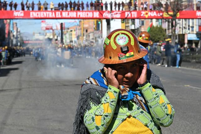 A woman gestures as miners march to La Paz in demand of Bolivia's President Rodrigo Paz's resignation in El Alto, Bolivia, on May 14, 2026. For the past two weeks, workers, farmers, school teachers, Indigenous groups and transport workers have been pressuring the government. Their demands range from wage increases and economic stabilization to opposition to the privatization of public companies. (Photo by AIZAR RALDES / AFP)