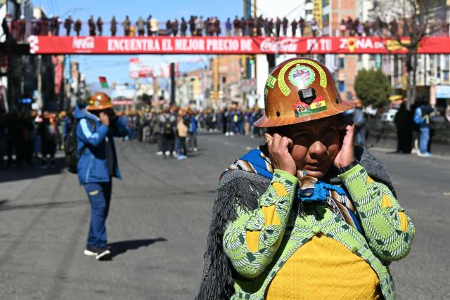 A woman gestures as miners march to La Paz in demand of Bolivia's President Rodrigo Paz's resignation in El Alto, Bolivia, on May 14, 2026. For the past two weeks, workers, farmers, school teachers, Indigenous groups and transport workers have been pressuring the government. Their demands range from wage increases and economic stabilization to opposition to the privatization of public companies. (Photo by AIZAR RALDES / AFP)