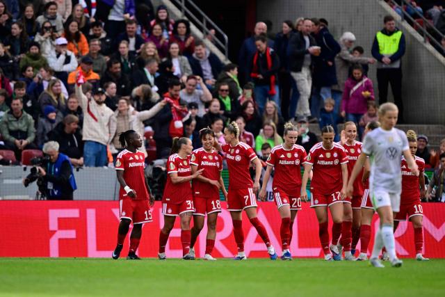 Bayern Munich's Japanese midfielder #18 Momoko Tanikawa (3rd L) is celebrated by team mates after scoring the 0-3 goal during the Women's German Cup (DFB-Pokal) final football match between VfL Wolfsburg and FC Bayern Munich in Cologne, western Germany, on Mai 14, 2026. (Photo by INA FASSBENDER / AFP) / DFB REGULATIONS PROHIBIT ANY USE OF PHOTOGRAPHS AS IMAGE SEQUENCES AND QUASI-VIDEO.